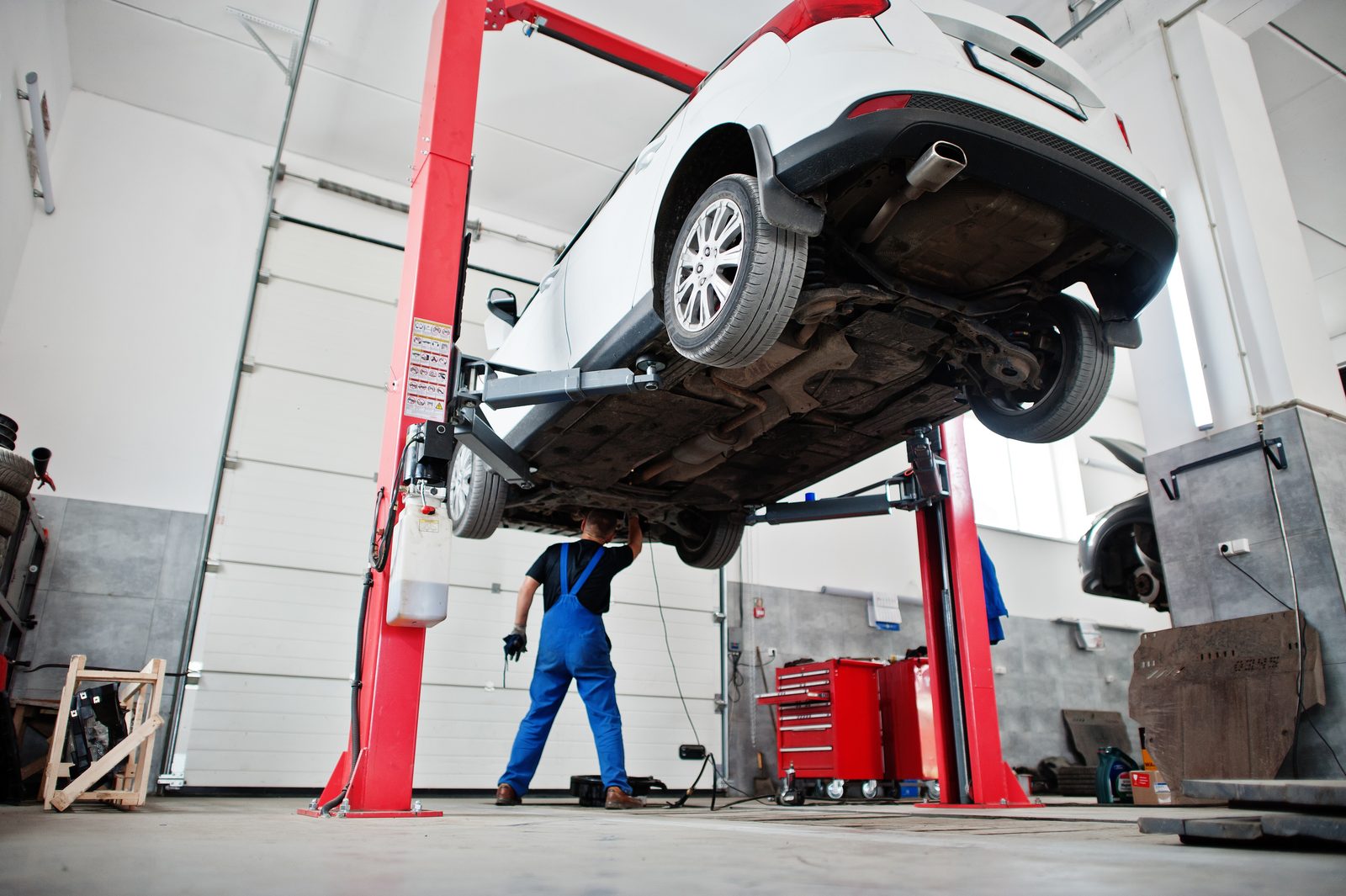 Vehicle raised on a two-post lift in a professional automotive workshop